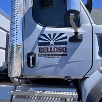 A white dump truck with a sticker on the side of it.