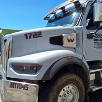 A large white semi truck is parked on the side of the road.