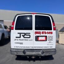 The back of a jr 's painting llc van is parked in a parking lot.