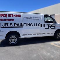 A white van is parked in front of a building.