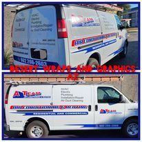 A white van with a company logo on it is parked on the side of the road.