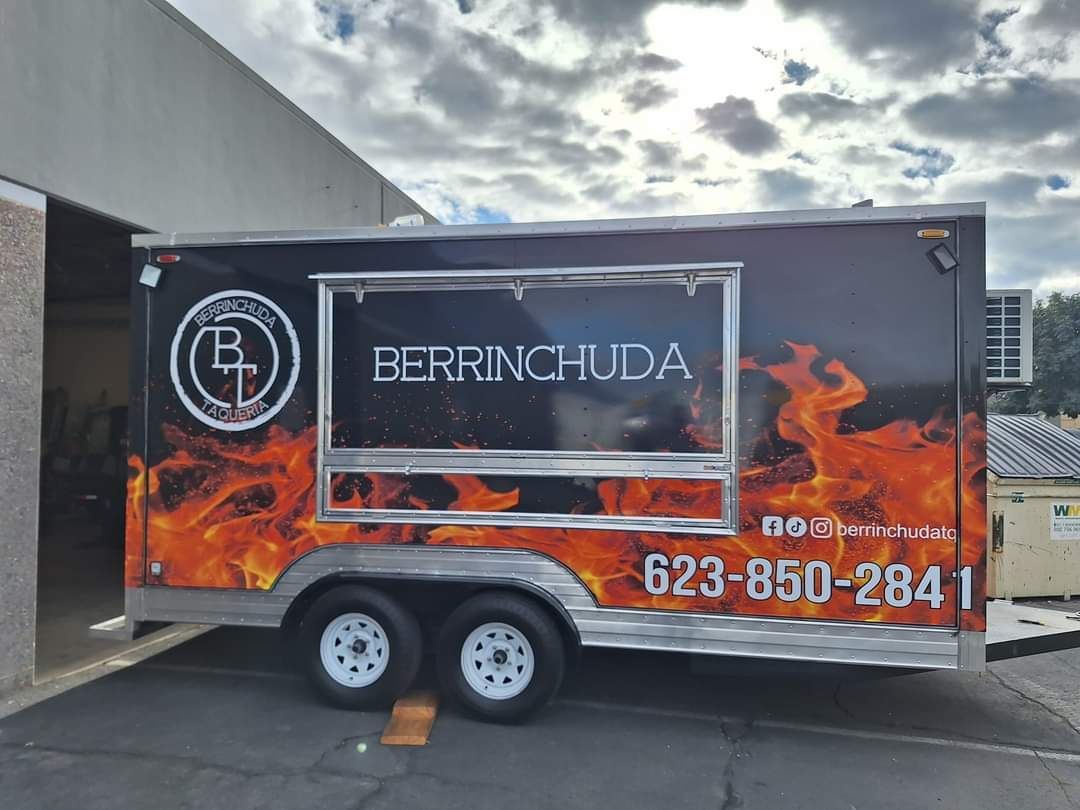 A food truck is parked in front of a building.