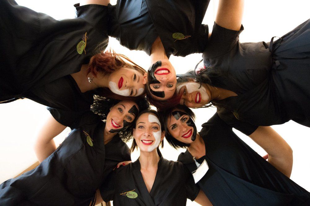Team di estetiste con maschere viso nere e bianche