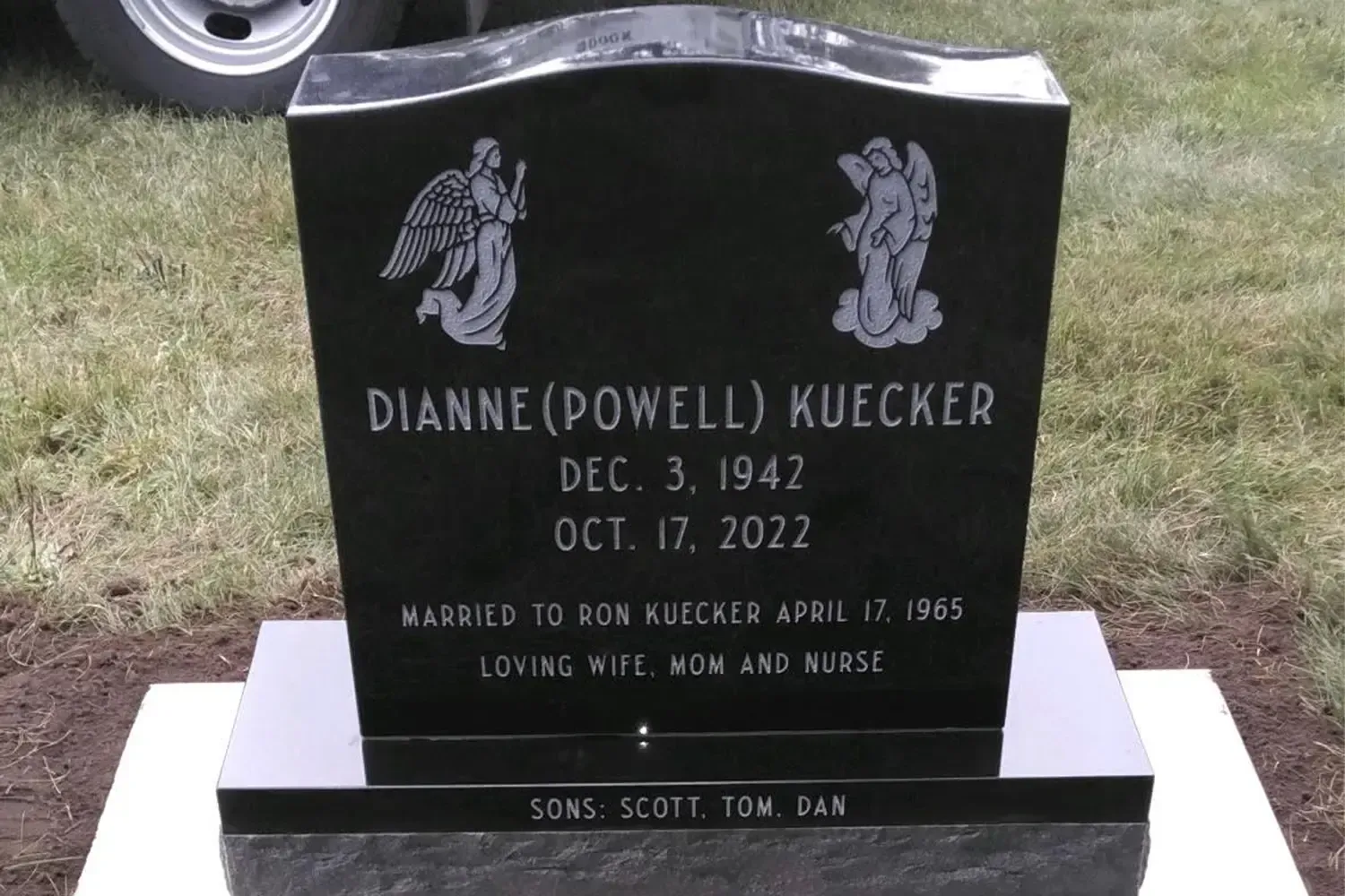 Black gravestone in a cemetery with white lettering for Dianne Powell Kuecker, 1942–2002
