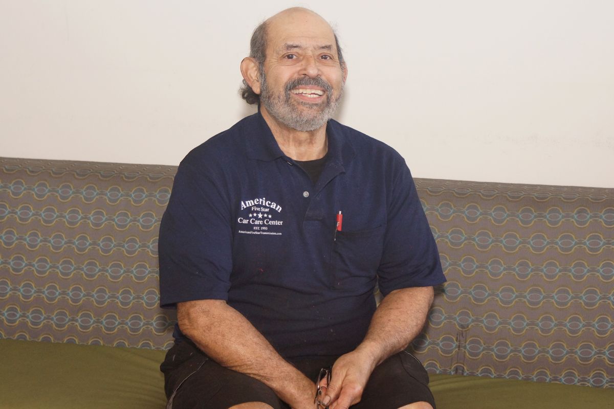 A man with a beard wearing a blue shirt that says ' portland ' on it