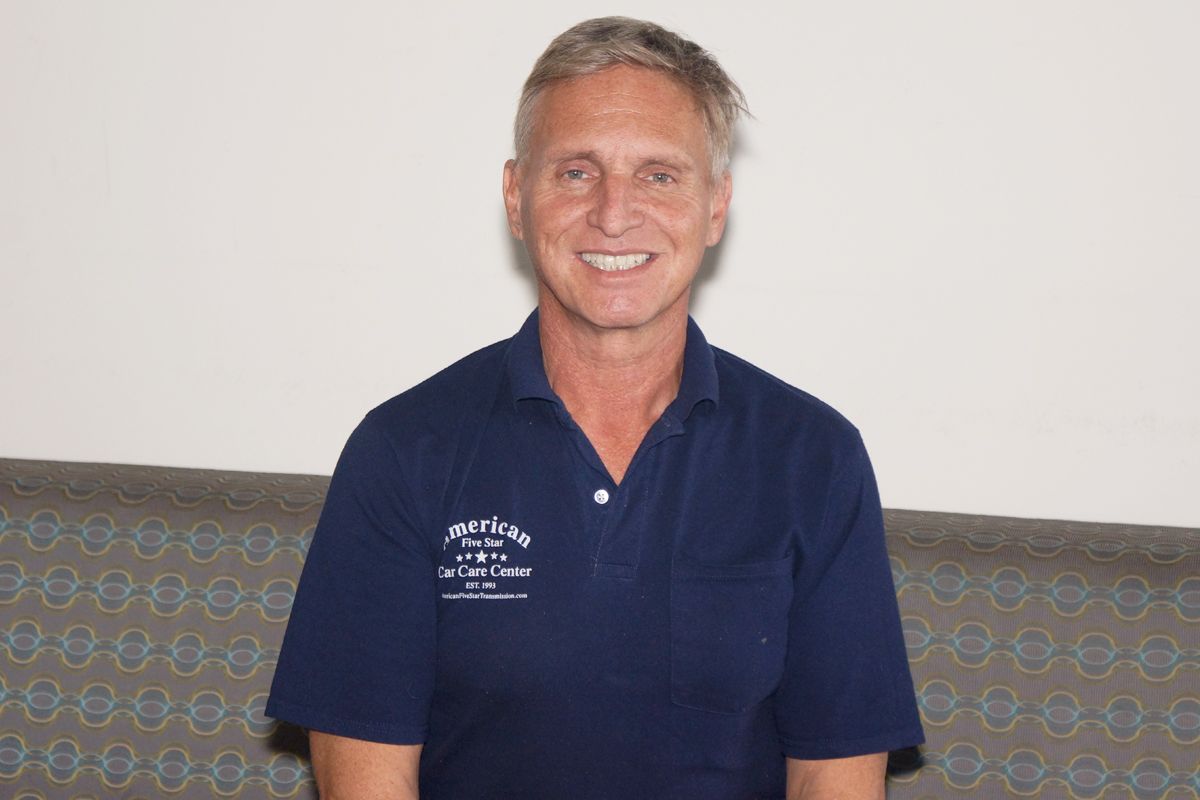 A man in a blue shirt is smiling for the camera