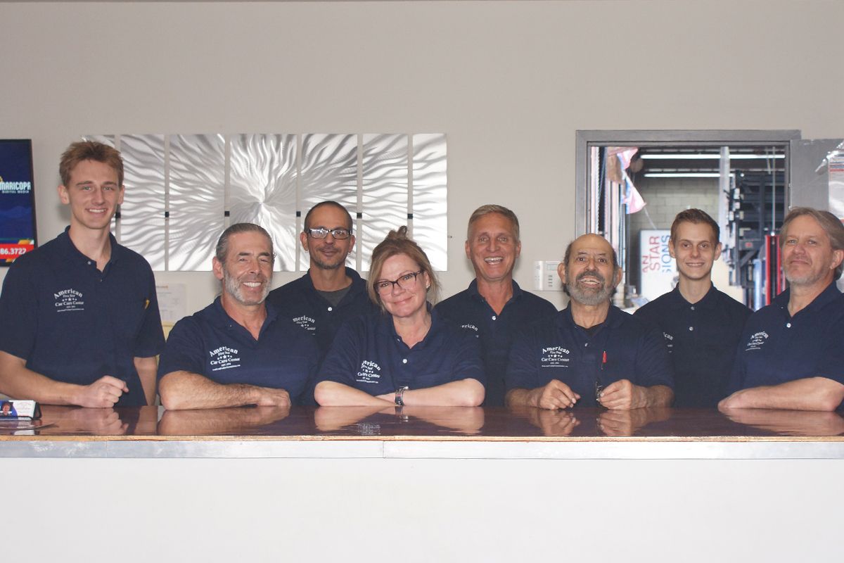 A group of people posing for a picture in front of a counter