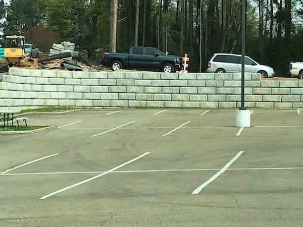 Concrete block retaining wall installed along a parking lot edge to stabilize elevation changes during a concrete block retaining wall service in Heber City, UT