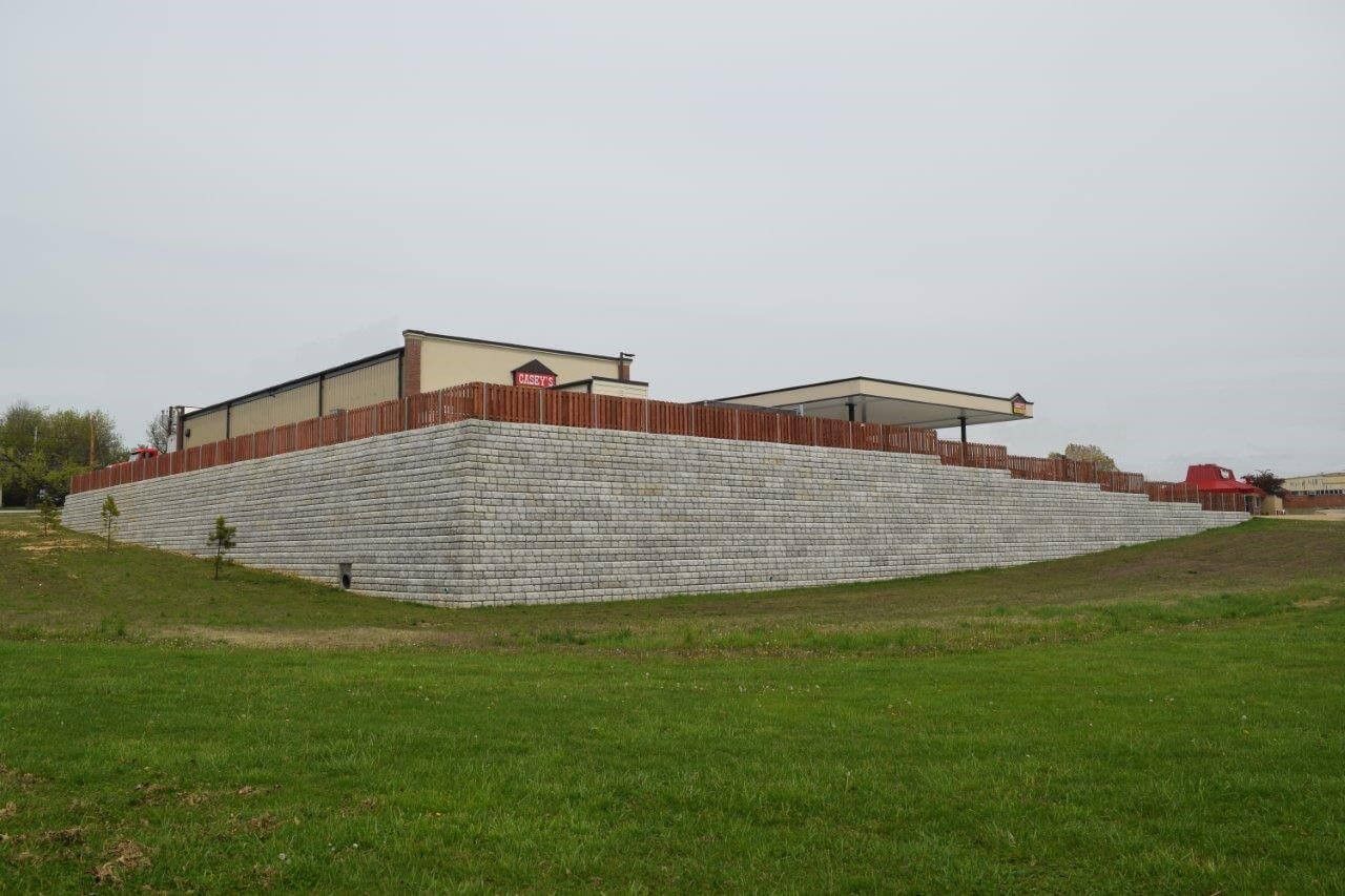 Extensive concrete block retaining wall stretching across a hillside to prevent erosion near a commercial site during a concrete block retaining wall service in Heber City, UT