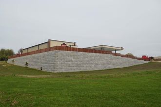 Extensive concrete block retaining wall stretching across a hillside to prevent erosion near a commercial site during a concrete block retaining wall service in Heber City, UT