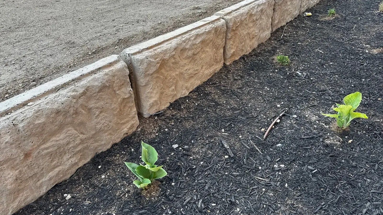 Close-up view of stacked concrete retaining wall blocks with clean alignment and soil edging during a concrete block retaining wall service in Heber City, UT