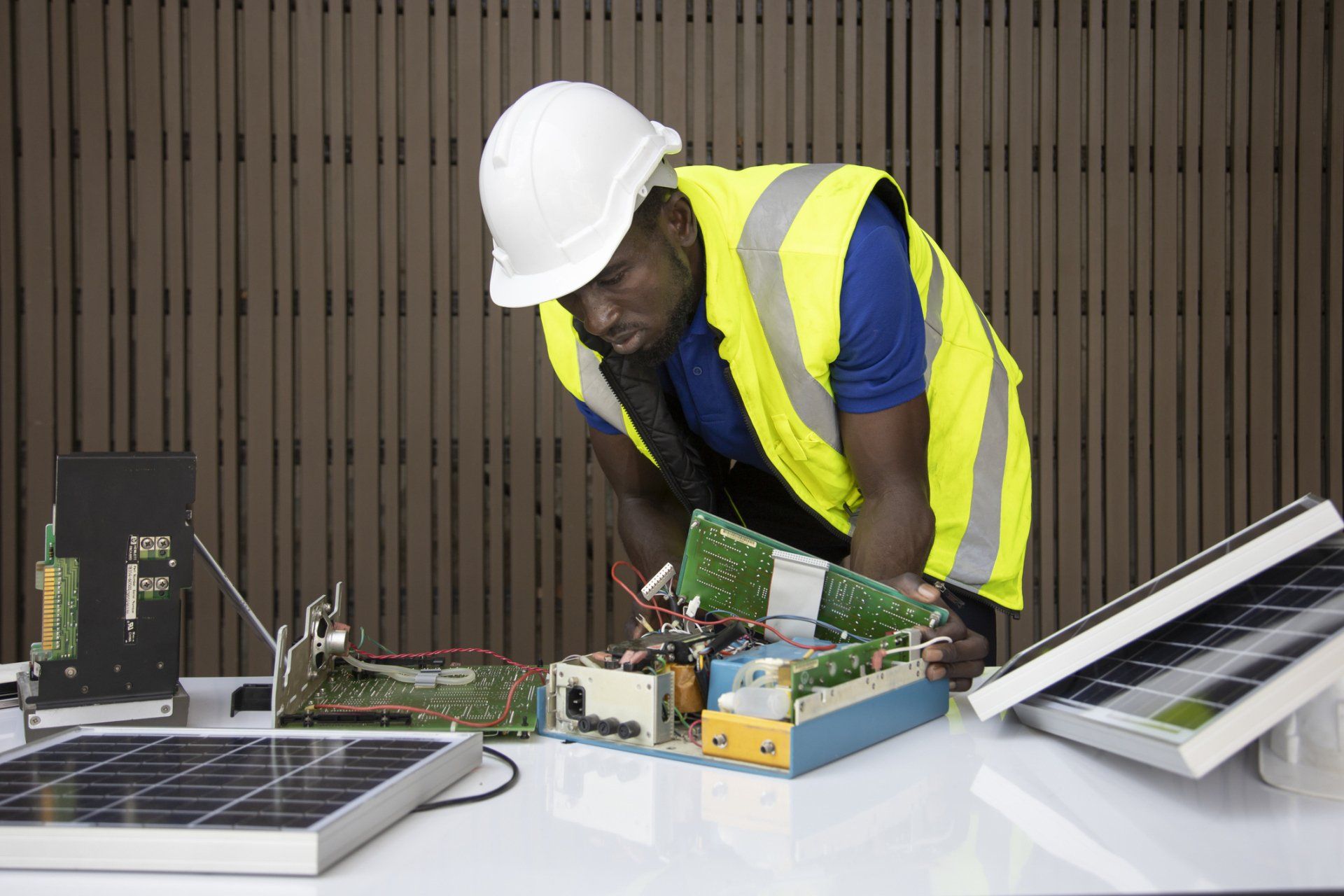 A Person Wearing a Safety Vest Working on a Circuit Board – Brisbane, QLD – Star Bright Energy