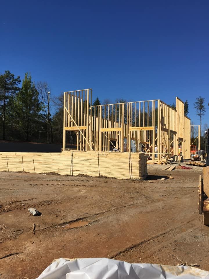 Construction of a wooden house frame; outdoors on a sunny day.