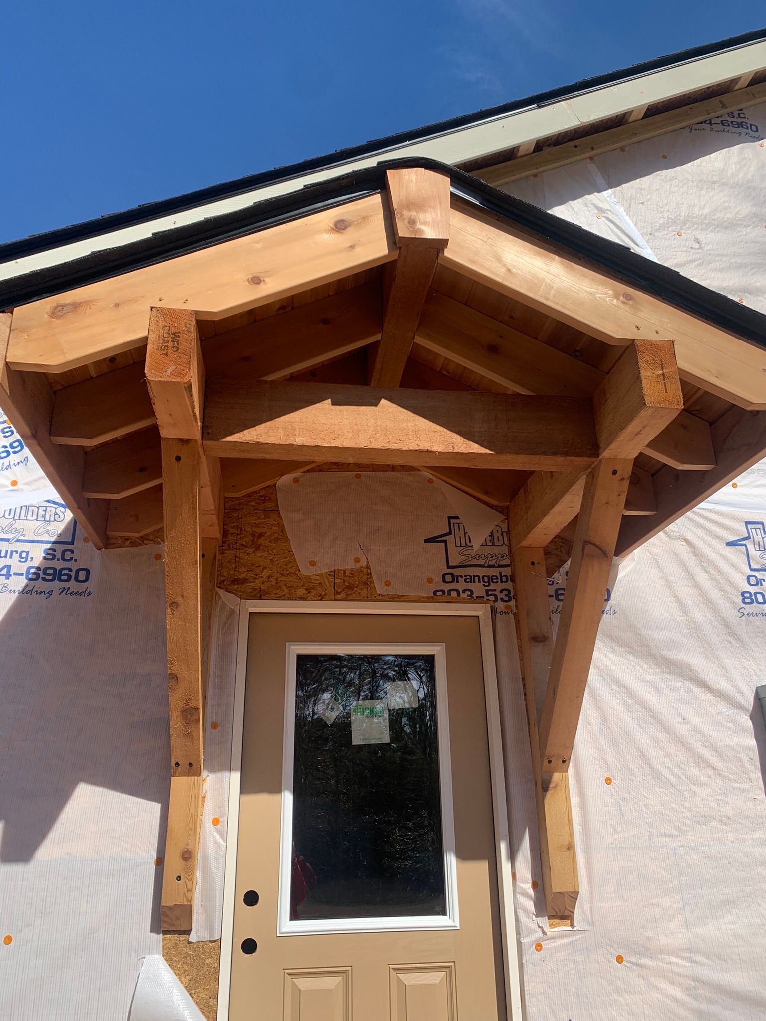 Wooden door frame over a light-colored door, on a building under construction.