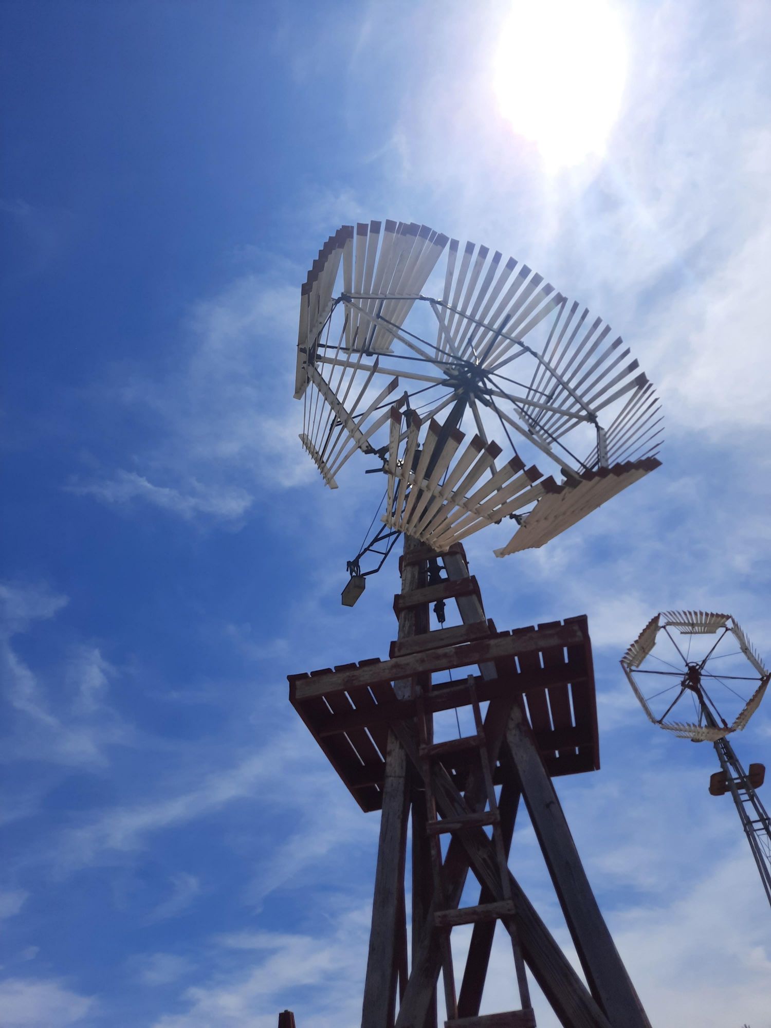 A windmill with a blue sky in the background