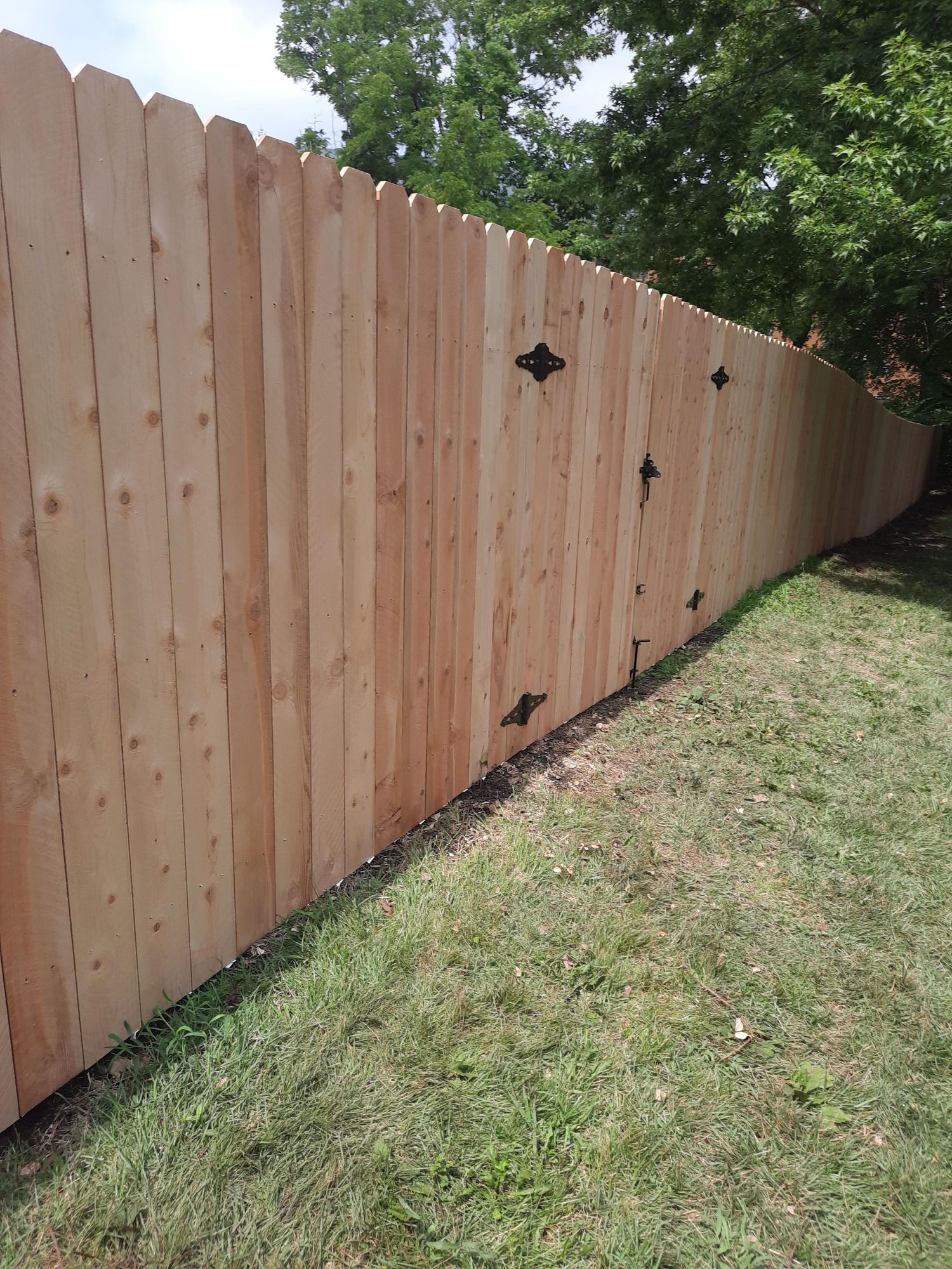 A wooden fence is sitting on top of a lush green lawn.