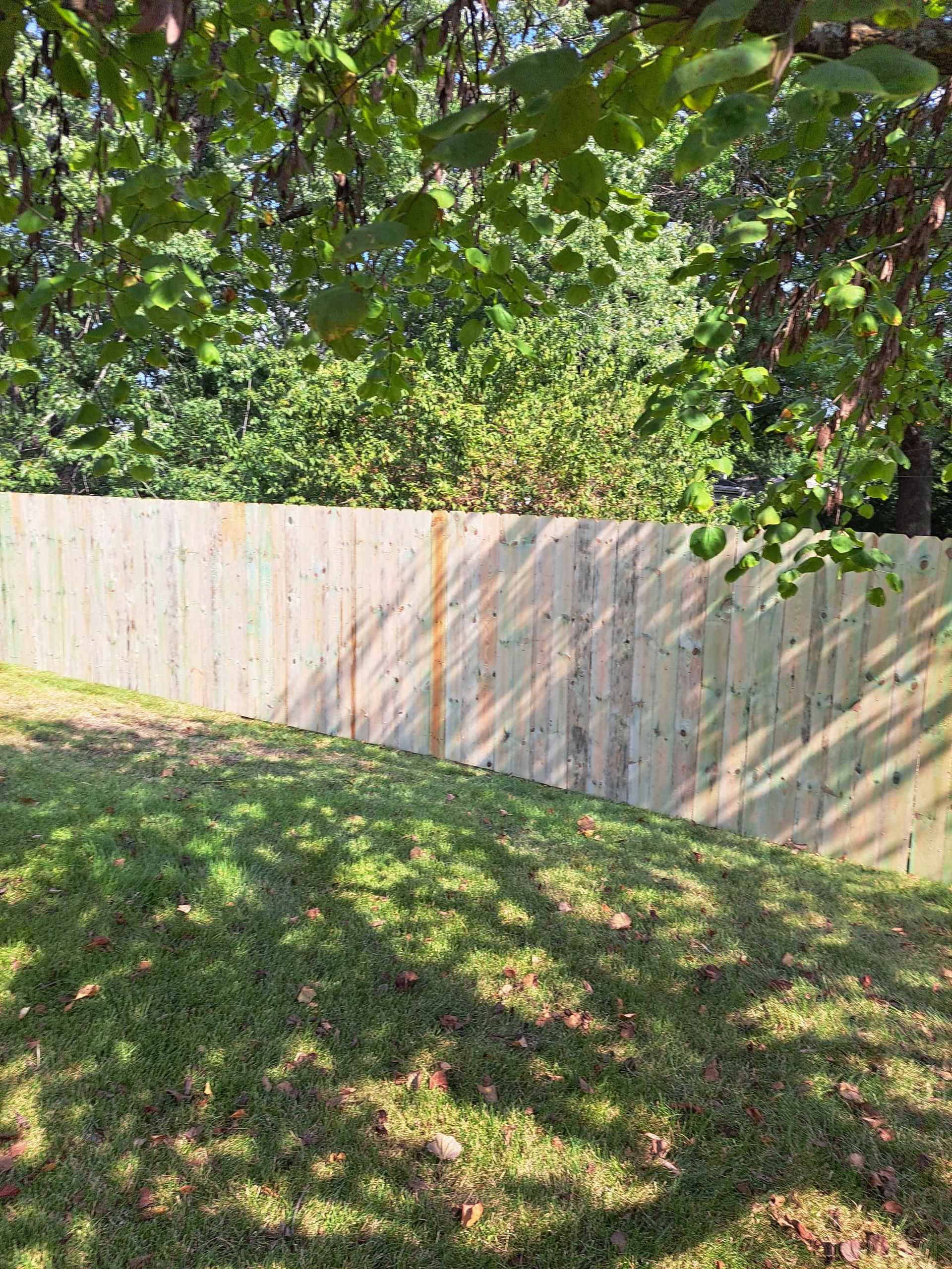 A wooden fence is sitting on top of a lush green lawn.