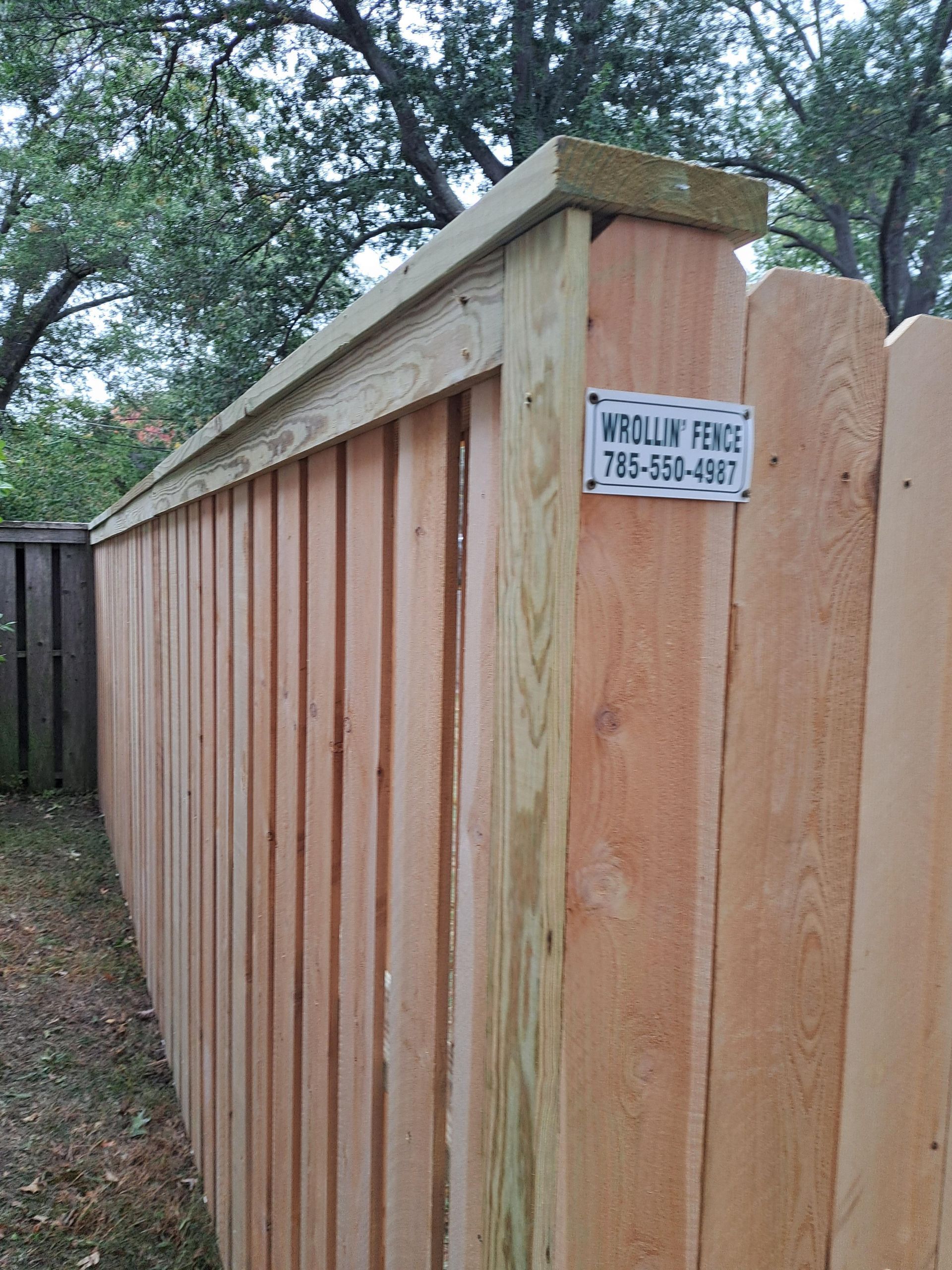 A wooden fence with a sign on it that says wholin fence