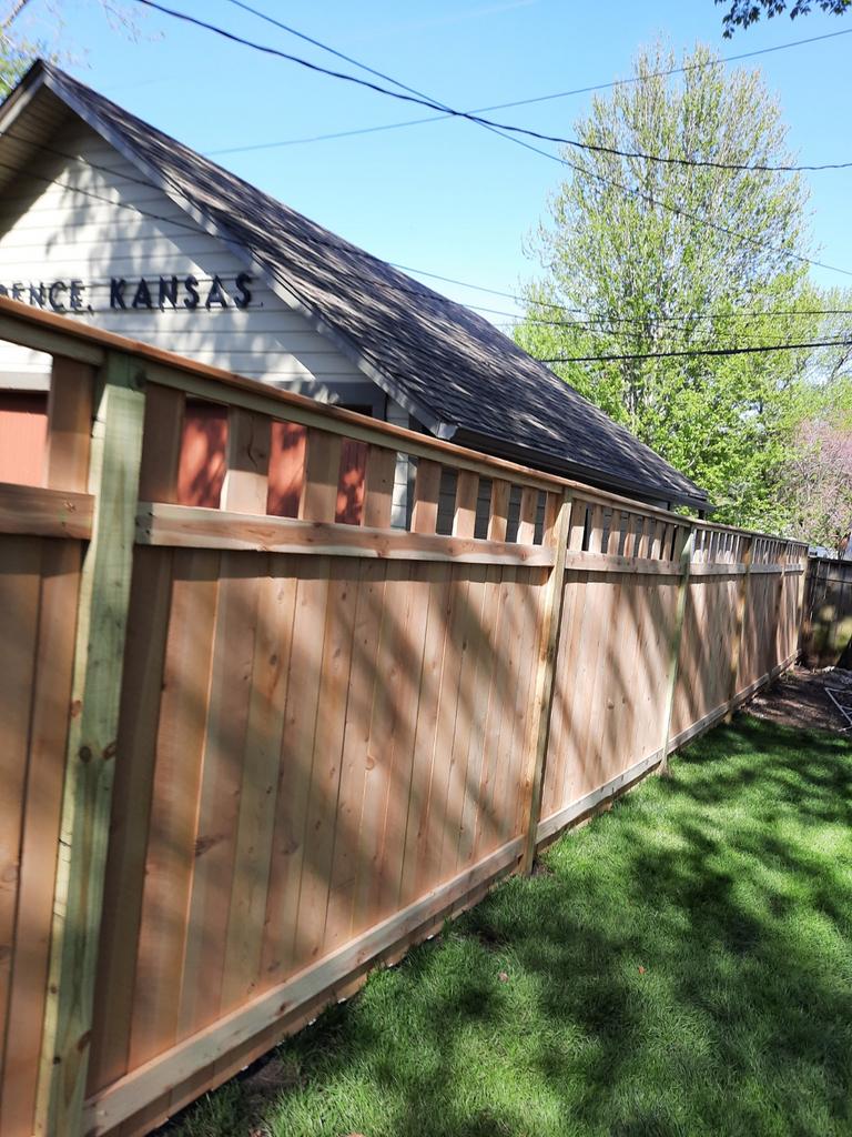 A wooden fence is sitting in front of a house.