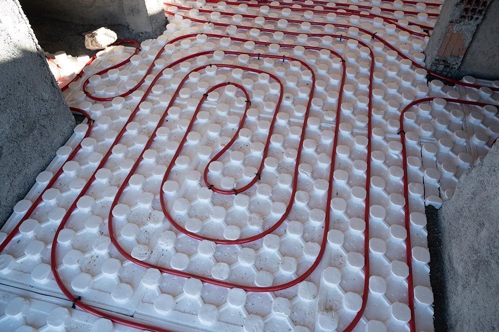 Red Tubing Laid in a Looped Pattern on White Insulation — Climate King In Orange, NSW