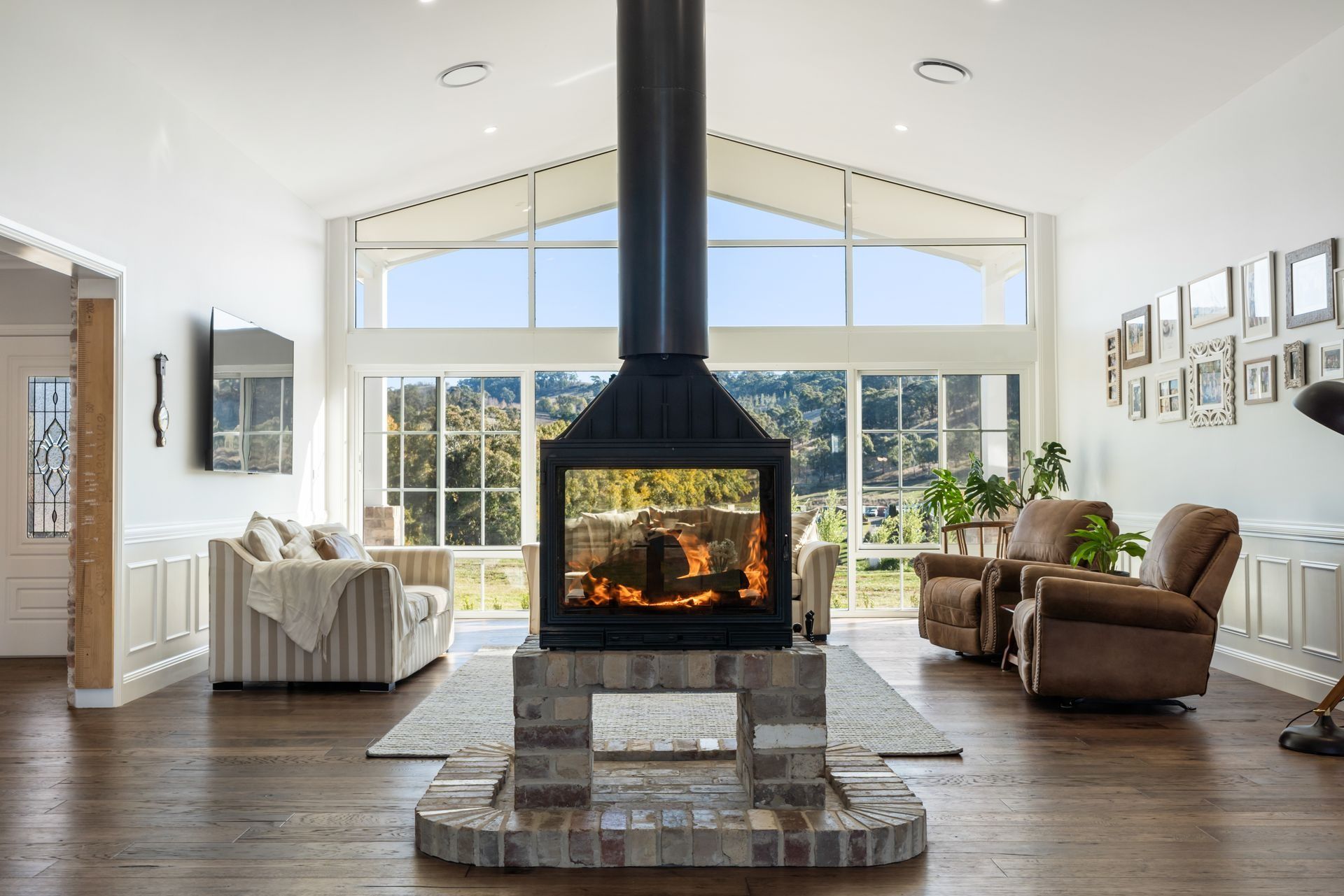 A Living Room With a Lit Fireplace, Armchairs  — Climate King In Orange, NSW