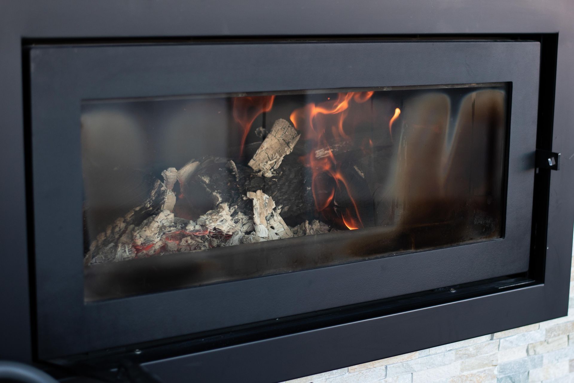 Fireplace With Burning Wood and Orange Flames Behind Glass Panel — Climate King In Orange, NSW
