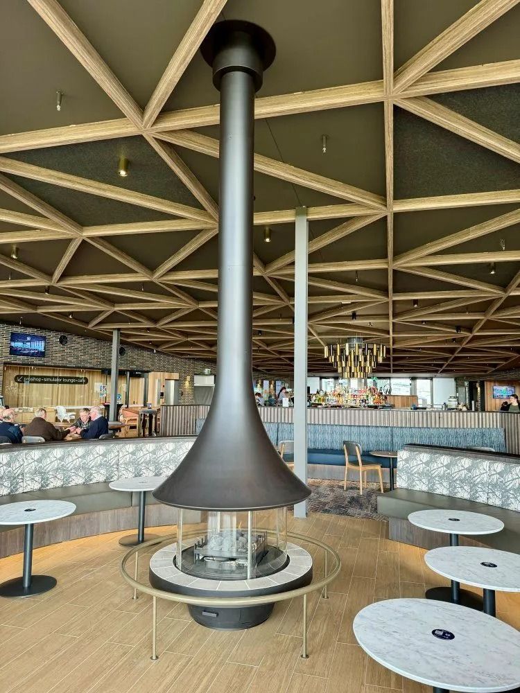 A Modern Fireplace With a Long, Black Chimney in a Public Seating Area — Climate King In Bathurst, NSW