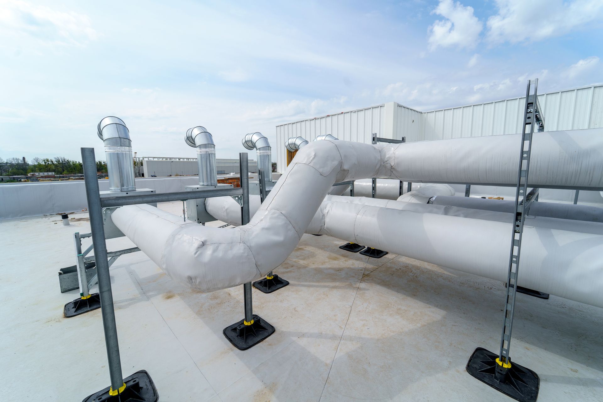 Pipes on a Flat Rooftop, Insulated With White Covering — Climate King In Orange, NSW