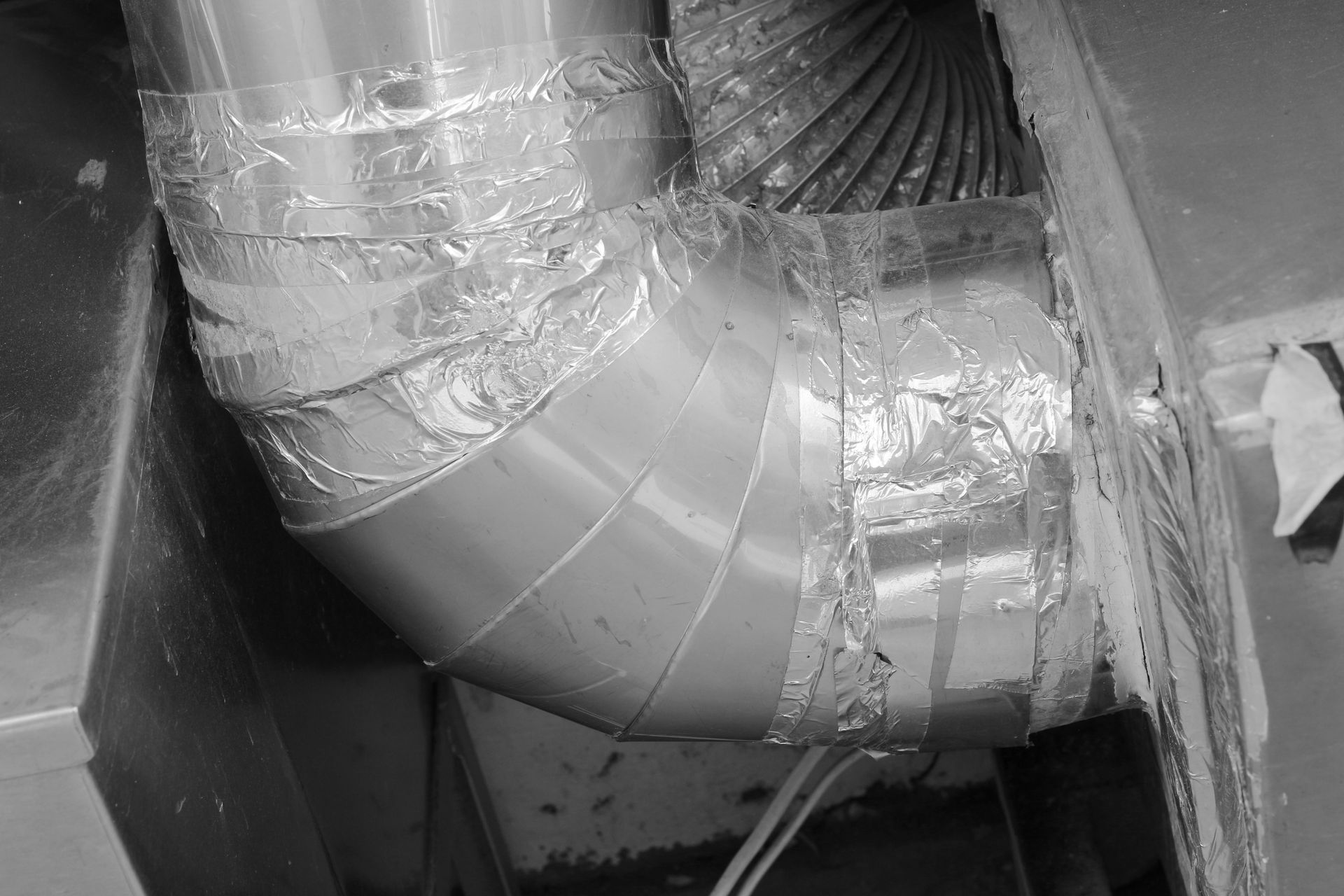Ductwork With Silver Tape and a Curved Pipe Connection — Climate King In Orange, NSW