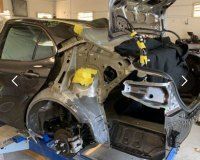 A car is being dismantled in a garage.