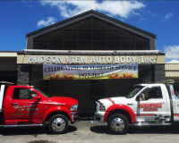 Two trucks are parked in front of a building that says hudson view auto body inc.