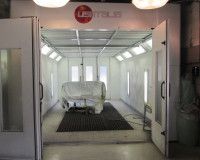 A car is being painted in a paint booth.