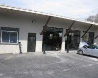 A car is parked in front of a car repair shop.