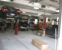 A car is sitting on a lift in a garage.