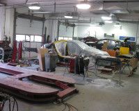 A car is being painted in a garage.