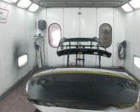 A car is being painted in a paint booth.