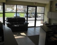 There is a couch in the middle of the room with a lot of windows.