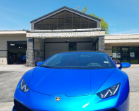 A blue lamborghini huracan is parked in front of a building.