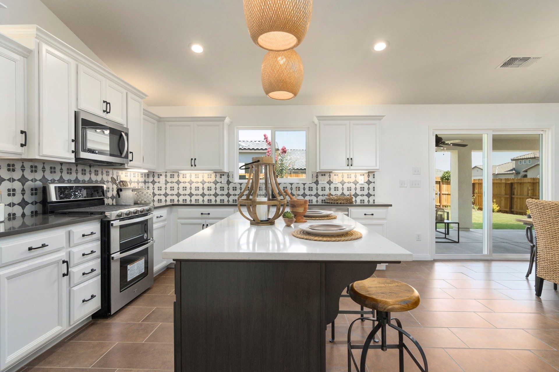 A kitchen with white cabinets , stainless steel appliances , and a large island.