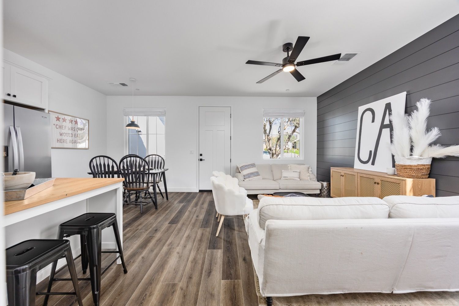 Modern living room with white walls, wood floors, and minimalist furniture.