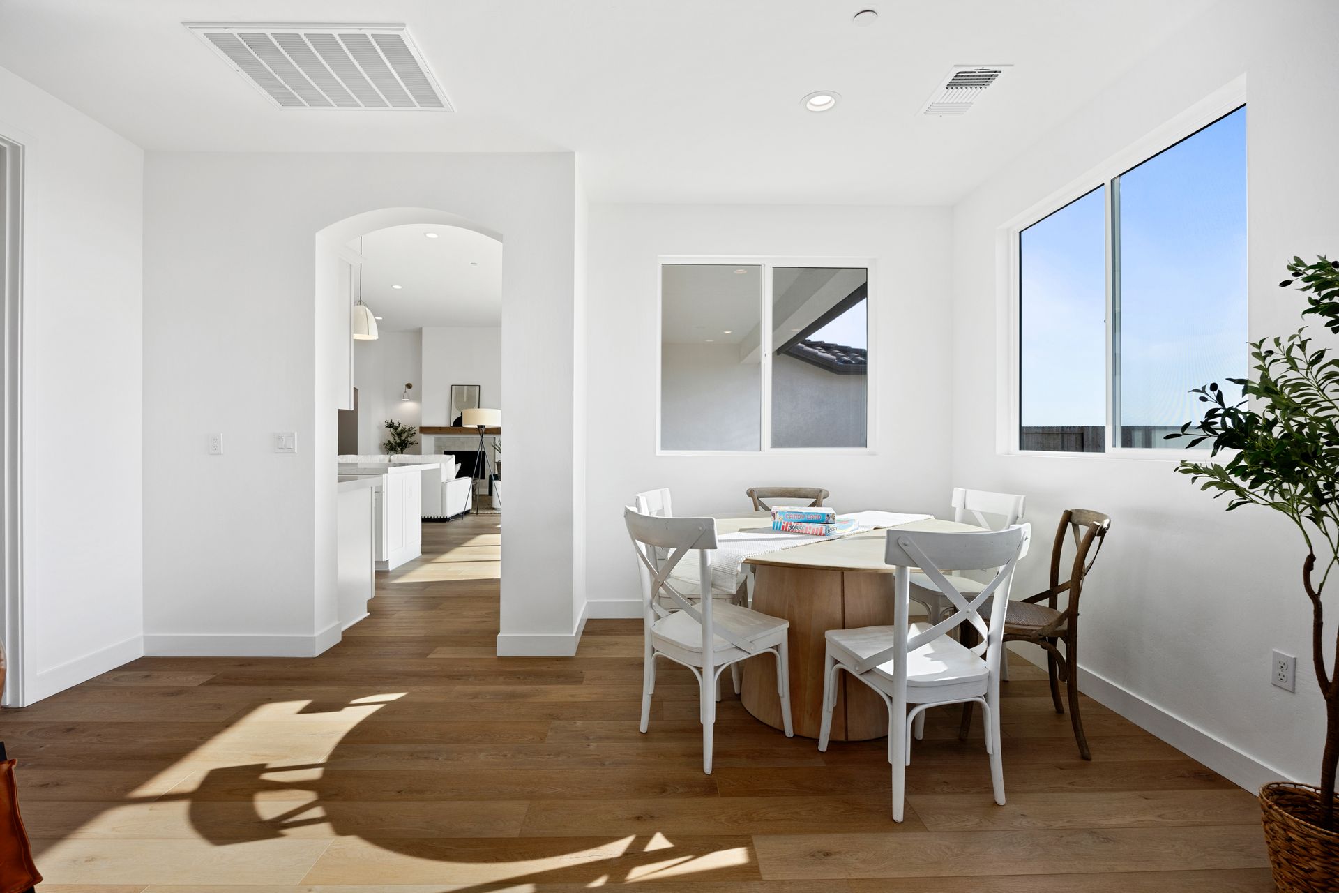 Dining room with round table, chairs, and window overlooking an outdoor view.