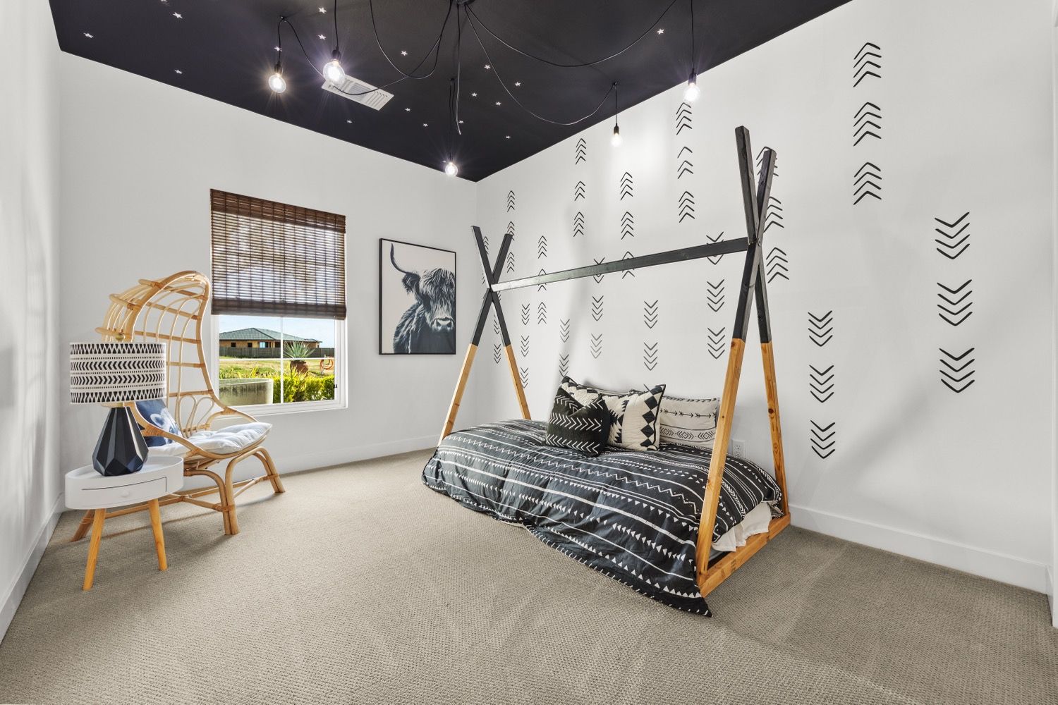 Bedroom with a black ceiling and black and white decor; teepee bed frame.