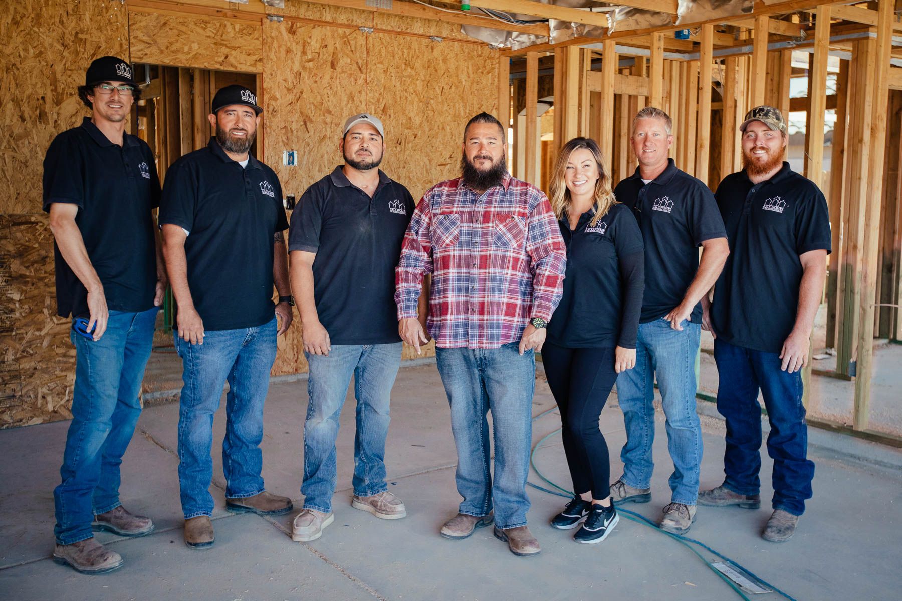 A group of construction workers are posing for a picture in a building under construction.