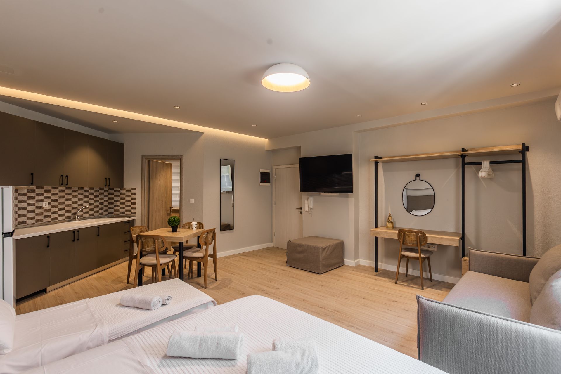 Modern studio apartment with a kitchenette, dining area, and living space.