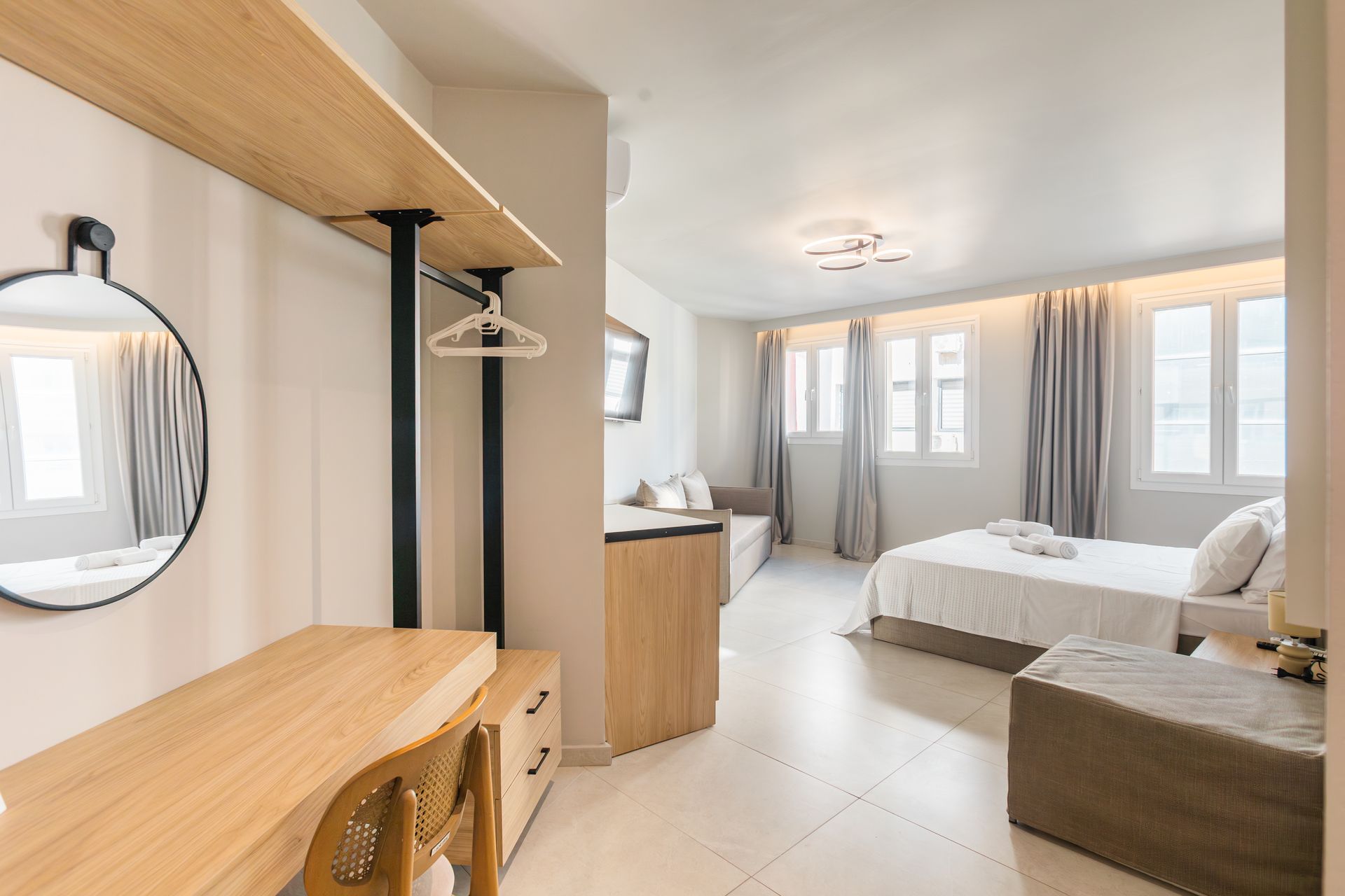 Bedroom with white walls, a bed, a desk, and a closet area.
