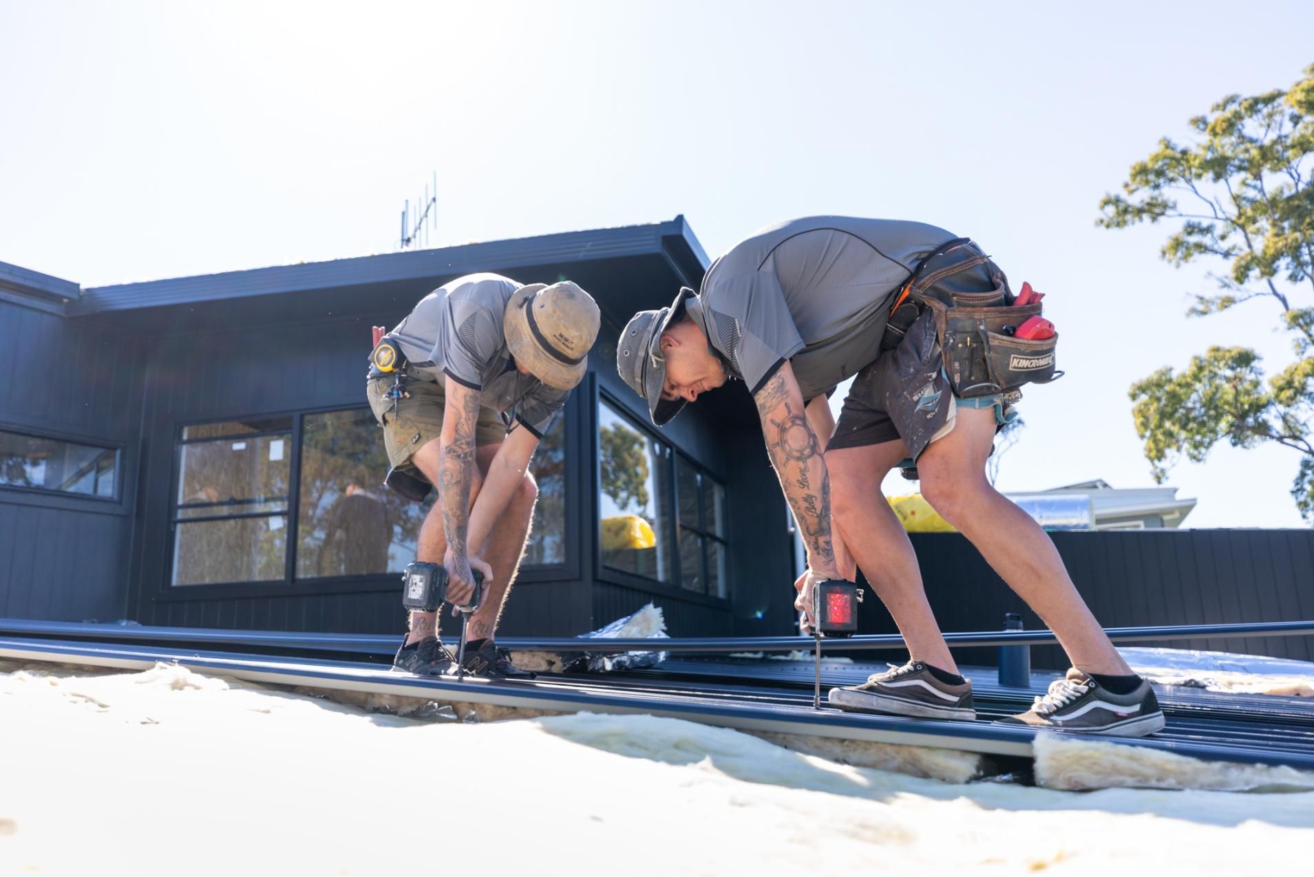 Two Men are Working on The Roof of a House — Roofing Contractor in Wauchope, NSW
