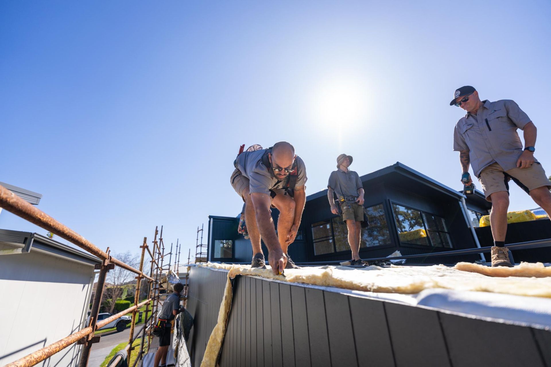 A Group of Construction Workers are Working on the House Roof — Roofing Contractor in Forster, NSW