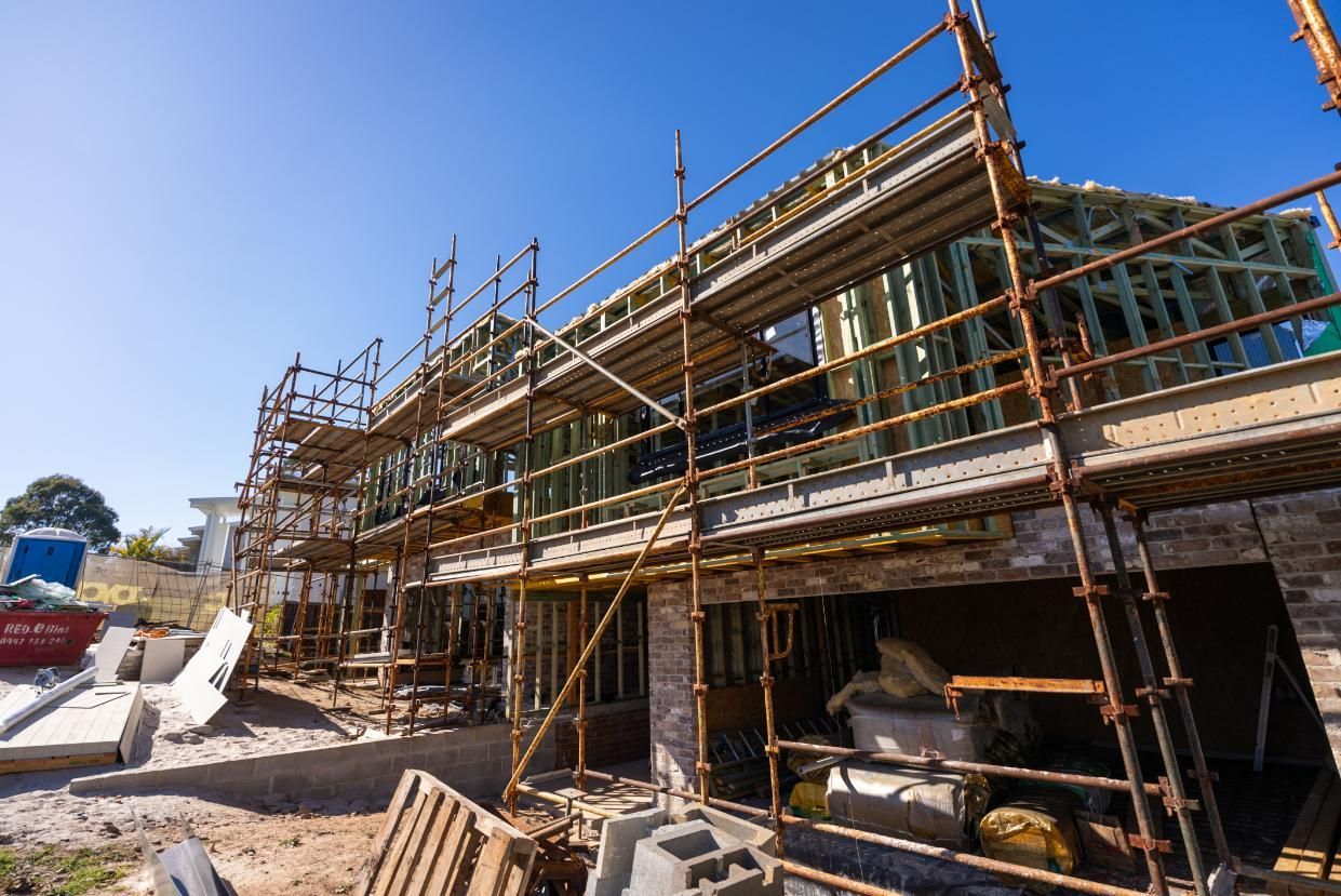 A House is Being Built With Scaffolding Around It — Roofing Contractor in Laurieton, NSW