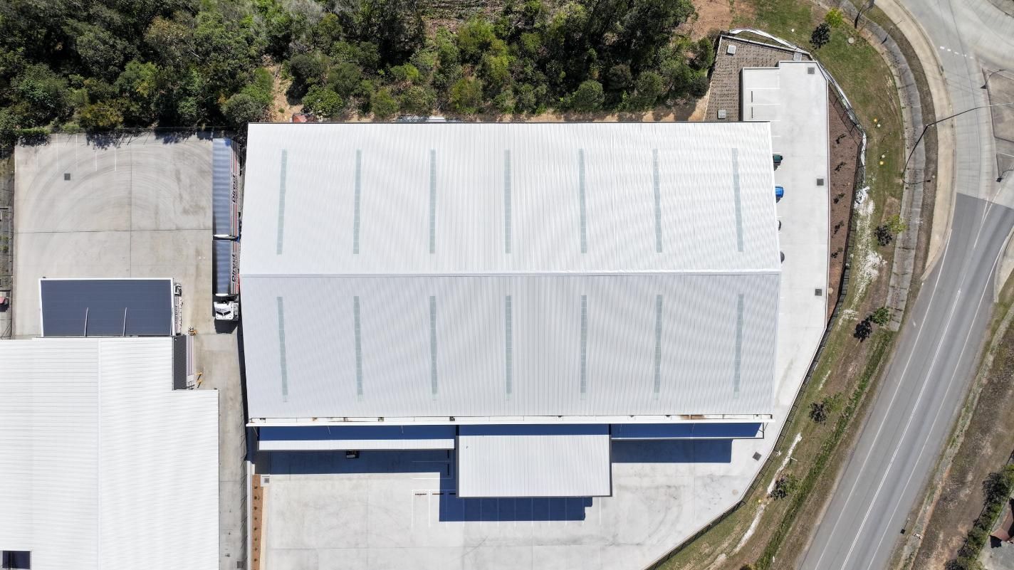 A Man is Working on a Roof With a Crane — Roofing Contractor in Wauchope, NSW