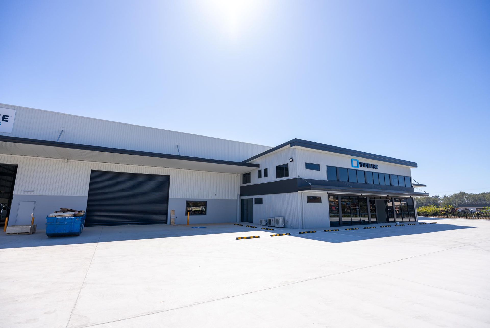 Two Men are Standing Next to a Stack of Yellow Rolls of Insulation — Roofing Contractor in Wauchope, NSW